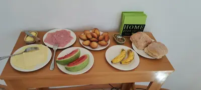 a table with plates of fruit and bread on it at Cap Ouest Praia in Praia