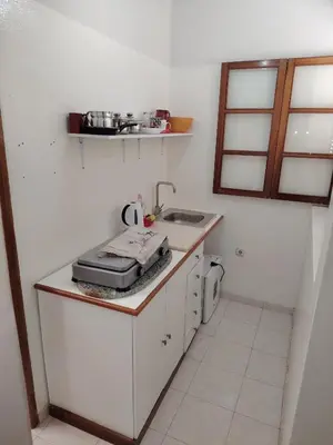 a small white kitchen with a sink and a stove at Maya Mindelo 2 in Mindelo