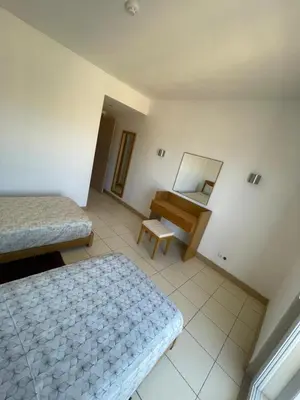 a room with two beds and a mirror and a piano at condomínio vila verde Pepper, Cactus T0,T1,T2 in Santa Maria
