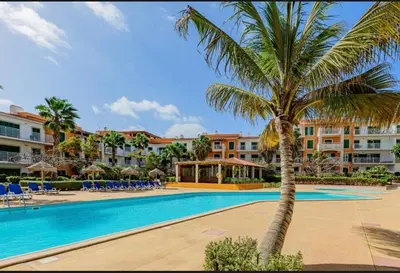 a palm tree next to a swimming pool at a resort at condomínio vila verde Pepper, Cactus T0,T1,T2 in Santa Maria