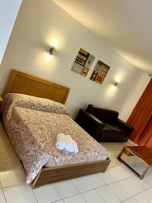 a bedroom with a bed and a couch and a chair at condomínio vila verde Pepper, Cactus T0,T1,T2 in Santa Maria