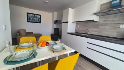 a kitchen with a table with plates and fruit on it at Appartamenti Praia Estoril, Sal Rei, Boa Vista in Sal Rei