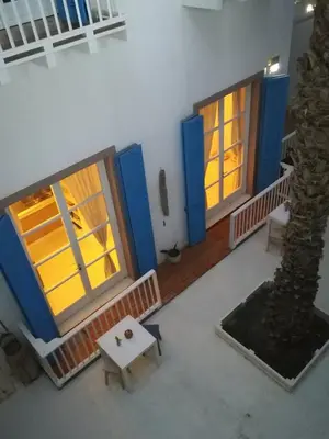 a room with two doors and a table and a tree at Appartamenti Praia Estoril, Sal Rei, Boa Vista in Sal Rei