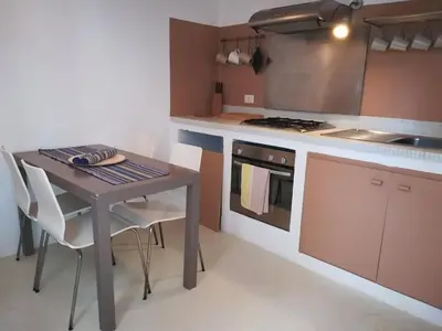 a kitchen with a table and a stove top oven at Appartamenti Praia Estoril, Sal Rei, Boa Vista in Sal Rei