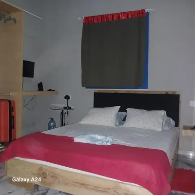 a bedroom with a large bed with a red blanket at Casa brunosky in Mindelo