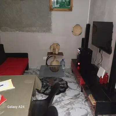 a living room with a table and a tv at Casa brunosky in Mindelo
