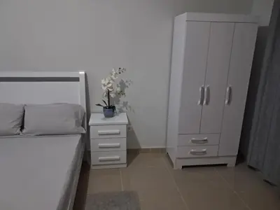 a bedroom with a bed and a cabinet and flowers at T0 Cabral Next Door in Sal Rei