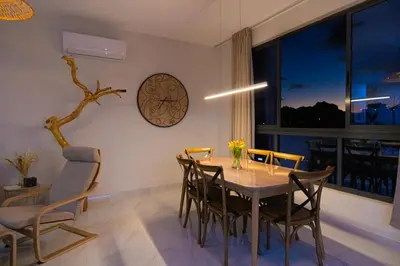 a dining room with a table and chairs and a clock at HouseLux JJL in Mindelo
