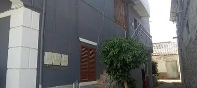 a blue building with a door and a plant next to it at Holiday's House in Praia