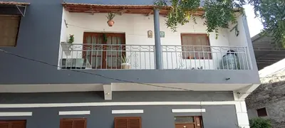 a white house with a balcony with plants on it at Holiday's House in Praia