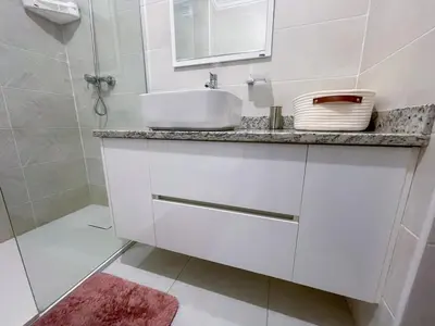 a white bathroom with a sink and a shower at Marel Bliss Apartments T2 Camila in Mindelo