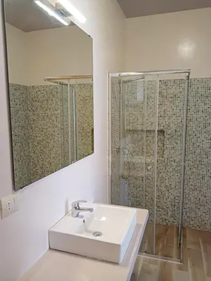 a white bathroom with a sink and a shower at Onda do Mar in Sal Rei