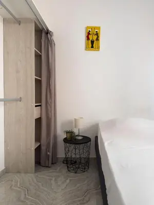 a bedroom with a bed and a table with a lamp at Spacious 3-bdr apartment - Palmarejo Grande - LCGR in Praia