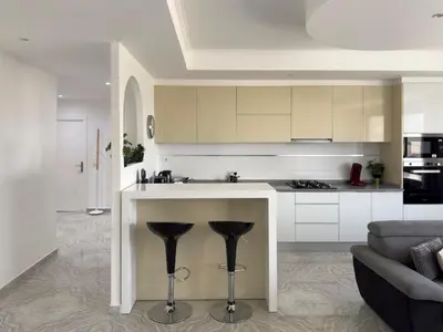 a kitchen with a counter with two stools at Spacious 3-bdr apartment - Palmarejo Grande - LCGR in Praia