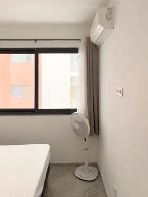 a bedroom with a bed and a lamp in front of a window at Spacious 3-bdr apartment - Palmarejo Grande - LCGR in Praia