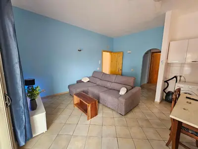a living room with a couch and a table at Bouganville Holiday Apartment in Santa Maria