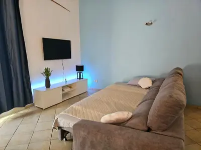 a bedroom with a couch and a flat screen tv at Bouganville Holiday Apartment in Santa Maria