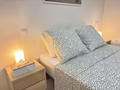 a bedroom with a bed and a side table with a lamp at Relax in Praia in comfort in Praia