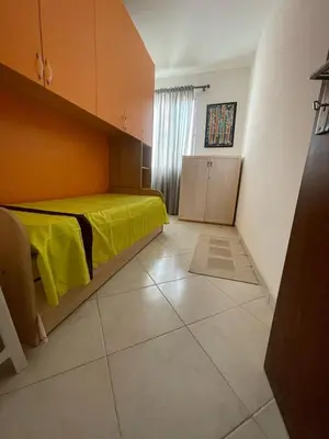 a bedroom with a bed with a yellow blanket on it at Two Bedroom Apt - 150 meters from the Beach in Santa Maria