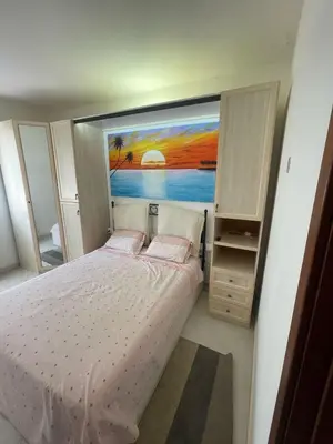 a bedroom with a bed with a painting on the wall at Two Bedroom Apt - 150 meters from the Beach in Santa Maria