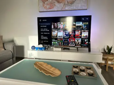 a living room with a tv and a remote control at Cozy Flat in Praia
