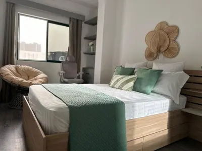 a bedroom with a large bed with green pillows at Cozy Flat in Praia