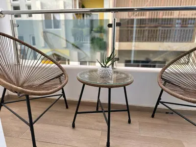 two chairs and a table with a vase on it at Cozy Flat in Praia