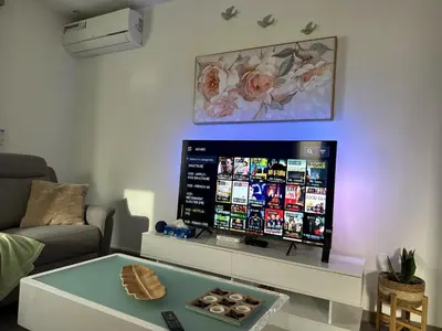 a living room with a flat screen tv on the wall at Cozy Flat in Praia