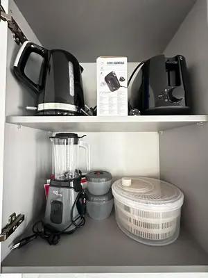 a kitchen shelf with a blender and other appliances at Cozy Flat in Praia