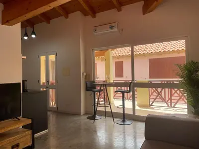 a living room with a table and a balcony at Island Retreat in Santa Maria