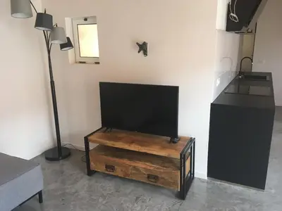 a living room with a flat screen tv and a table at Island Retreat in Santa Maria