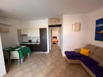 a living room and kitchen with a table and a couch at Brisa Tropical in Santa Maria