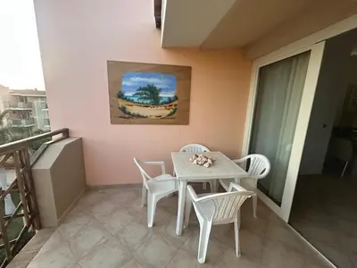 a white table and chairs on a balcony with a painting at Brisa Tropical in Santa Maria