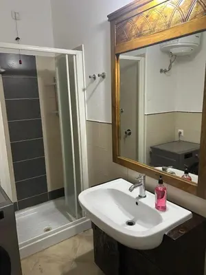 a bathroom with a sink and a shower with a mirror at Brisa Tropical in Santa Maria