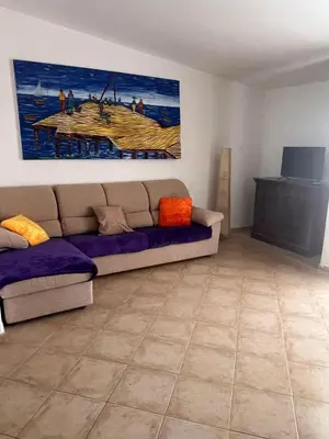 a living room with a couch and a painting on the wall at Brisa Tropical in Santa Maria