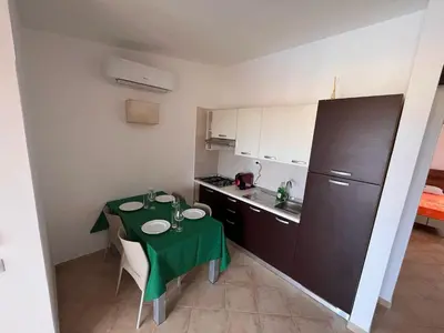 a small kitchen with a table with a green table cloth at Brisa Tropical in Santa Maria