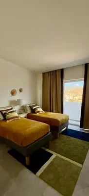 a hotel room with two beds and a window at Laginha Paradise II - Penthouse in Mindelo