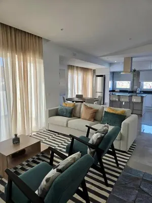a living room with a couch and chairs and a kitchen at Laginha Paradise II - Penthouse in Mindelo