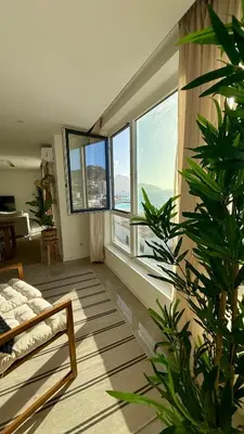a living room with a bed and a large window at Laginha Paradise III in Mindelo