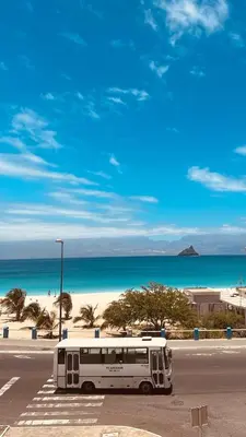 a bus parked in a parking lot next to the beach at Laginha Paradise III in Mindelo