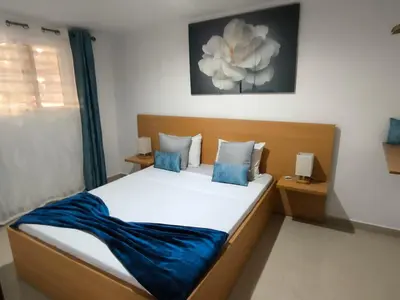 a bedroom with a bed with a blue blanket on it at Old Town view Apartment in Cidade Velha
