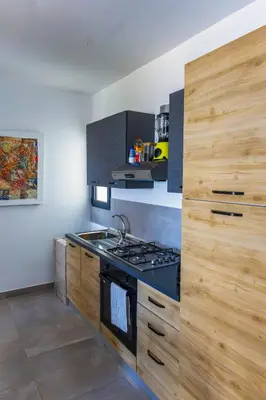 a kitchen with a stove and wooden cabinets at Ocean View Luxury in Santa Maria