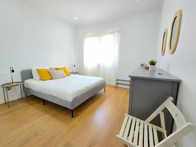 a bedroom with a bed with yellow pillows and a window at Casa Bela in Mindelo