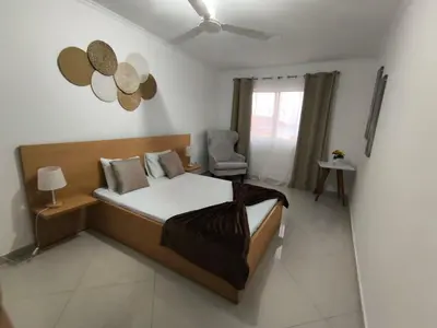 a bedroom with a bed and a chair in it at Ocean view Apartment 2 in Cidade Velha