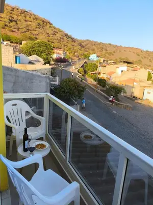 a balcony with a table and chairs and a street at Ocean view Apartment 2 in Cidade Velha