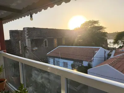 a view from a balcony of a building with the sunset at Catedral View Apartment in Cidade Velha