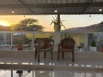two chairs sitting on a porch with the sunset in the background at Catedral View Apartment in Cidade Velha