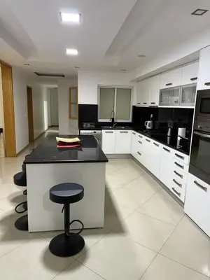 a kitchen with white cabinets and a black counter top at Casa Cucuia in Praia