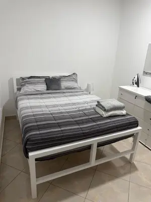 a bed in a white room with a white counter at Casa Cucuia in Praia