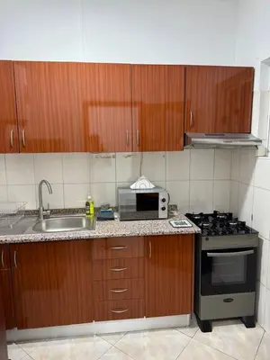 a kitchen with a sink and a stove and a microwave at Casa Cucuia in Praia